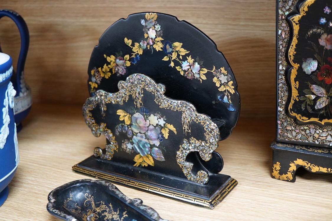Four 19th century mother of pearl inlaid papier mache items, to include, a four drawer cabinet, 26.5cm high, a tea caddy, letter rack and pen dish